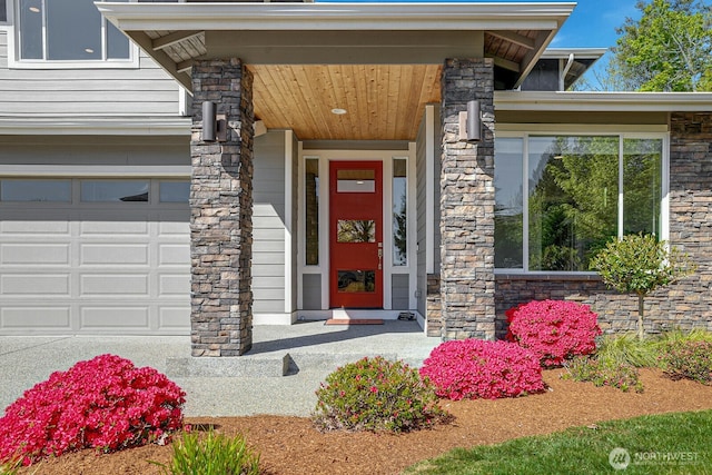 entrance to property featuring stone siding and an attached garage