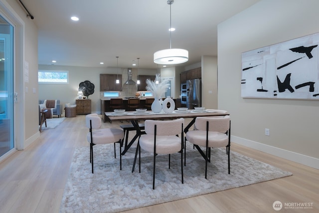 dining space featuring recessed lighting, baseboards, and light wood finished floors