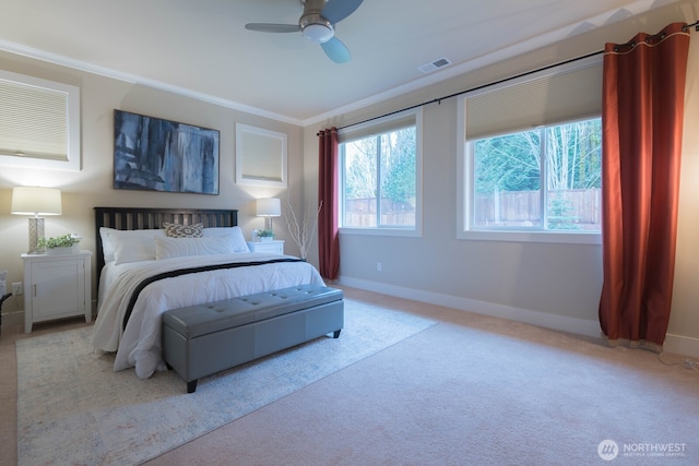 carpeted bedroom featuring a ceiling fan, visible vents, crown molding, and baseboards