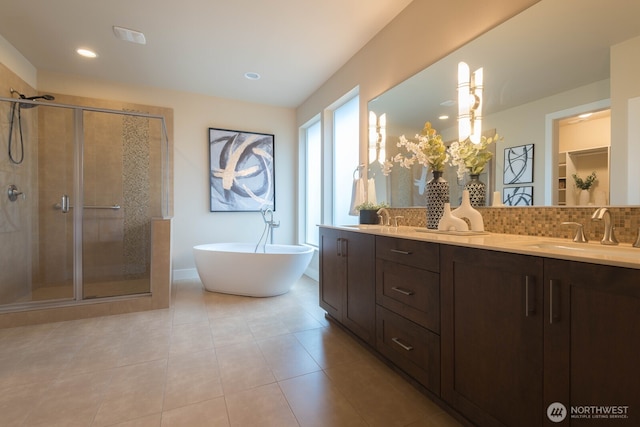 full bath with a sink, a shower stall, and decorative backsplash