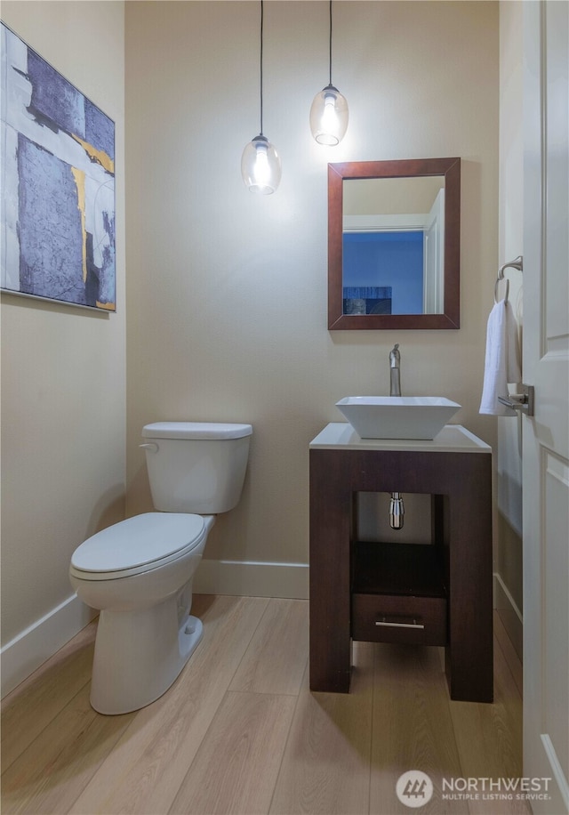 bathroom with vanity, toilet, and baseboards