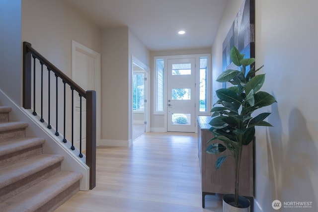 foyer featuring light wood-style floors, stairs, baseboards, and recessed lighting