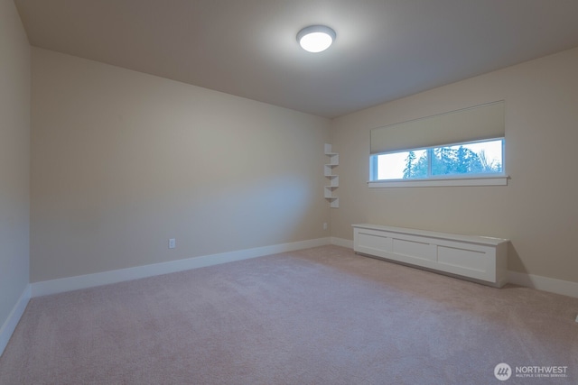 empty room with light colored carpet and baseboards