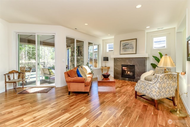 living room featuring a high end fireplace and wood-type flooring