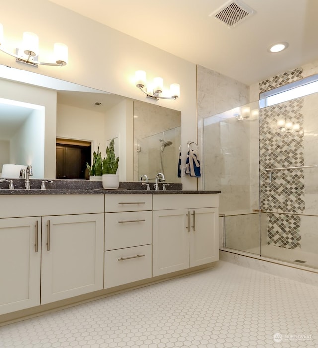 bathroom with vanity and a shower with door