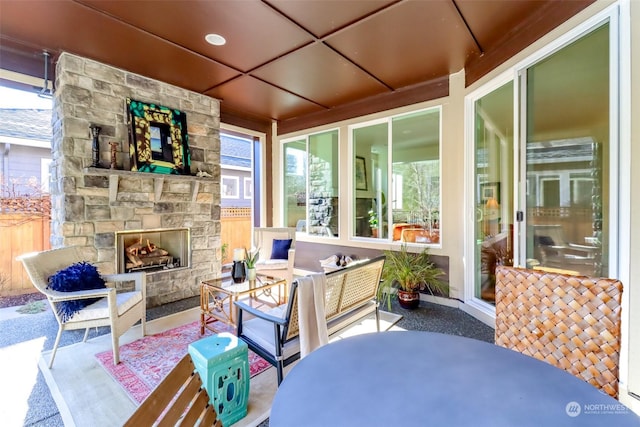 sunroom / solarium with plenty of natural light and an outdoor stone fireplace