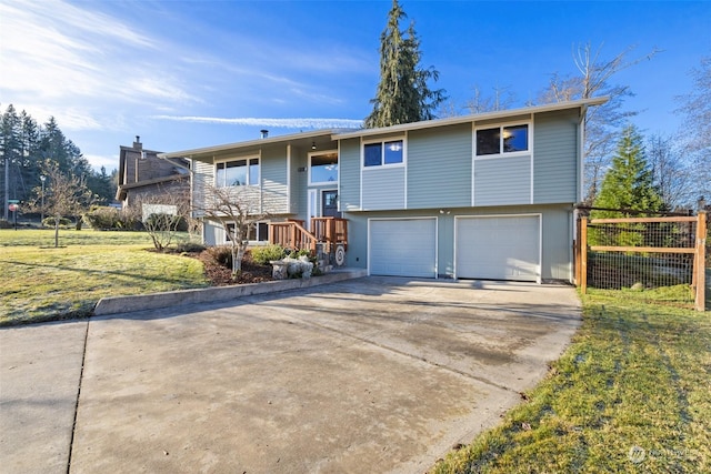 raised ranch featuring a garage and a front lawn