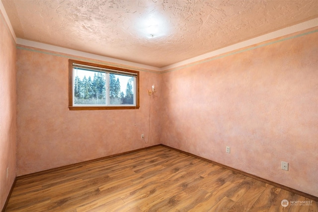 empty room with hardwood / wood-style flooring and a textured ceiling