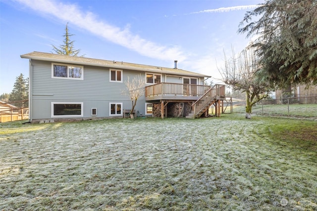 back of property with a wooden deck and a yard