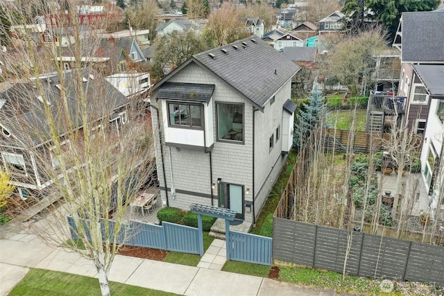 view of front of house featuring roof with shingles and fence