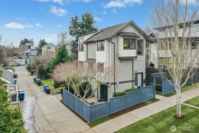 view of side of home featuring fence and a residential view