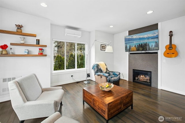 living room featuring recessed lighting, radiator, dark wood-type flooring, a warm lit fireplace, and a wall mounted air conditioner