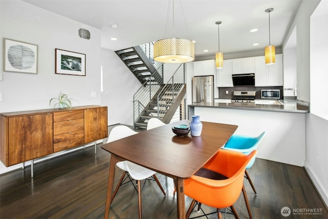 dining room featuring recessed lighting, dark wood finished floors, and stairway