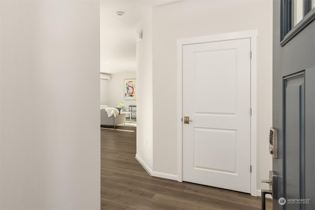 hallway with a wall mounted air conditioner and dark hardwood / wood-style floors