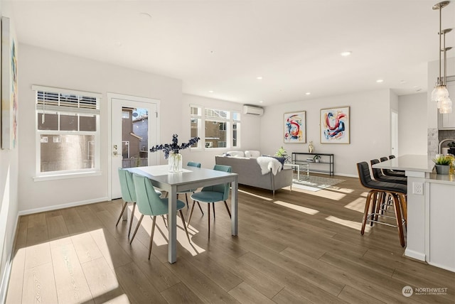 dining space featuring dark hardwood / wood-style flooring and a wall mounted air conditioner