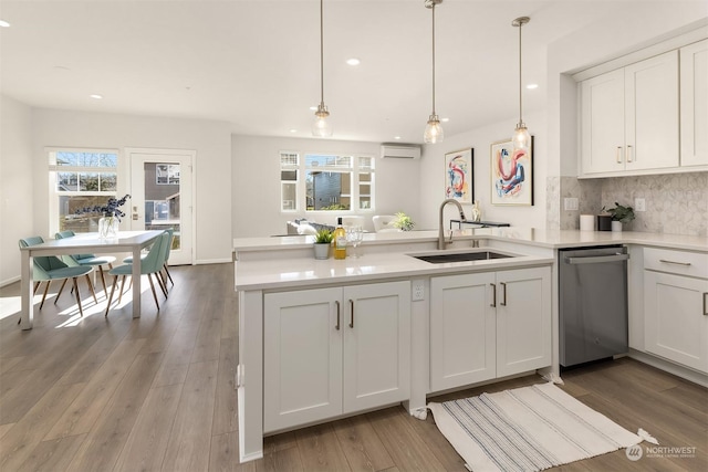 kitchen with pendant lighting, dishwasher, sink, and white cabinets