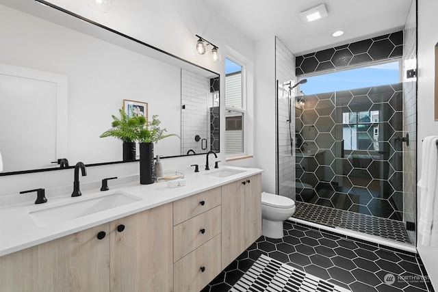 bathroom featuring vanity, a wealth of natural light, tile patterned floors, and toilet