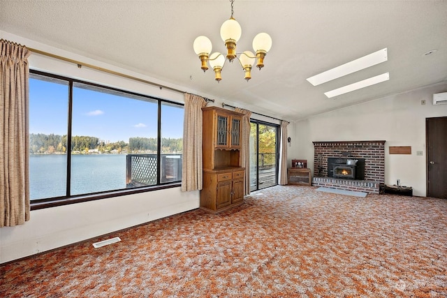 unfurnished living room with carpet flooring, a textured ceiling, vaulted ceiling with skylight, and a water view