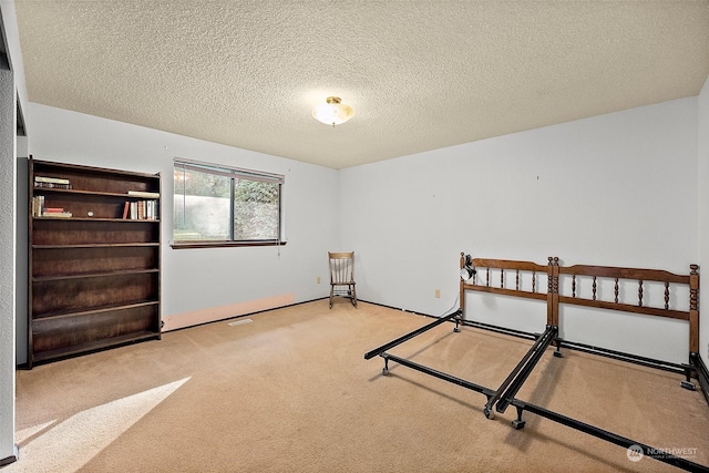 bedroom with light carpet and a textured ceiling