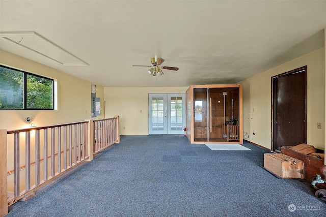 unfurnished room with french doors, ceiling fan, dark carpet, and a wealth of natural light