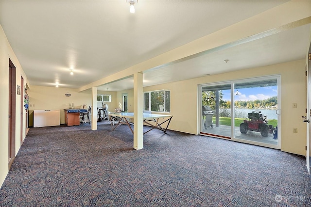 rec room with a water view and dark colored carpet