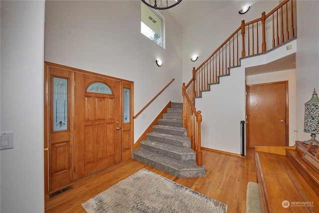 entryway featuring a high ceiling and light hardwood / wood-style floors