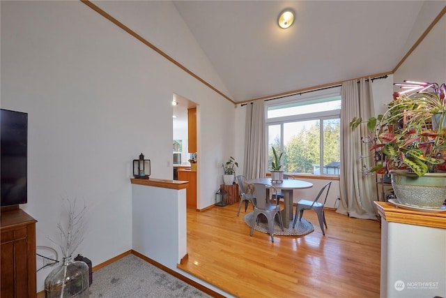 dining space featuring hardwood / wood-style flooring and vaulted ceiling