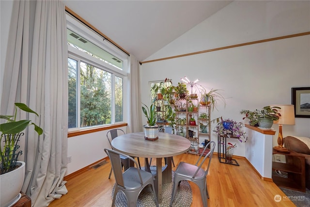 dining space featuring lofted ceiling and light hardwood / wood-style floors