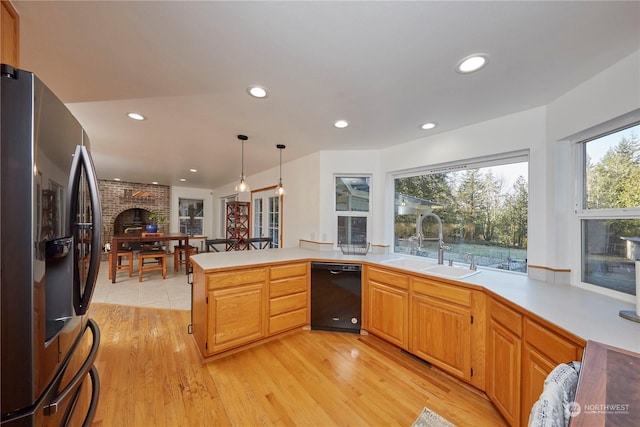 kitchen featuring sink, stainless steel fridge, dishwasher, kitchen peninsula, and light wood-type flooring