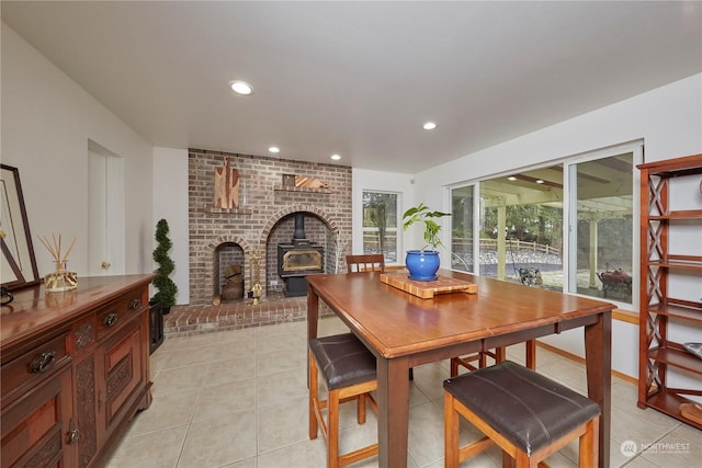 dining area featuring light tile patterned flooring and a wood stove