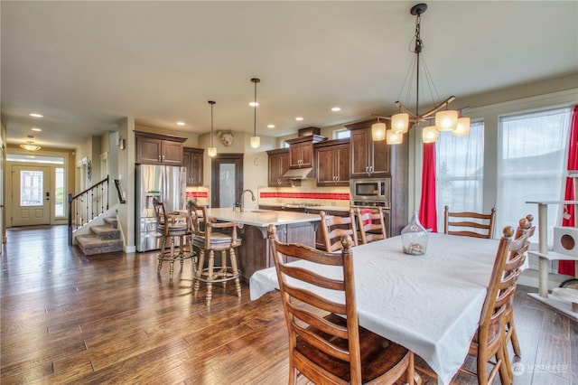 dining space with sink and dark wood-type flooring