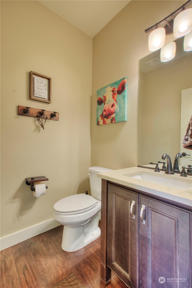 bathroom featuring hardwood / wood-style flooring, vanity, and toilet