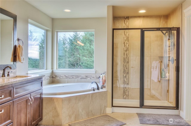 bathroom featuring shower with separate bathtub, a healthy amount of sunlight, and vanity