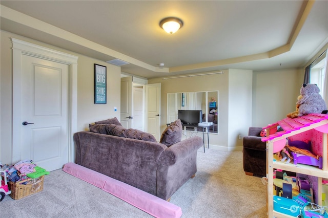 carpeted living room featuring a tray ceiling