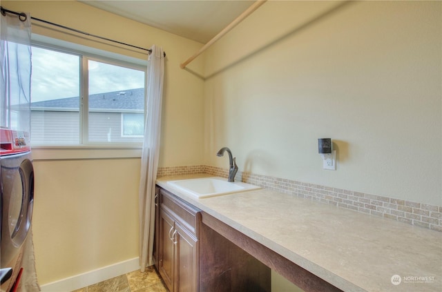 laundry room with cabinets, washer / dryer, and sink