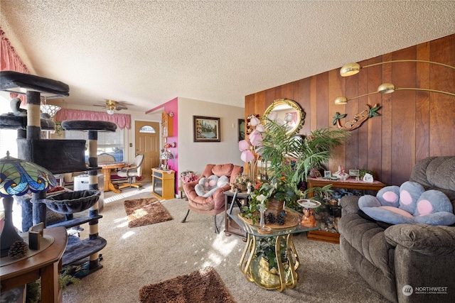 living room featuring carpet, a textured ceiling, and wood walls