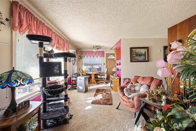 living room with ceiling fan, a textured ceiling, a healthy amount of sunlight, and carpet flooring