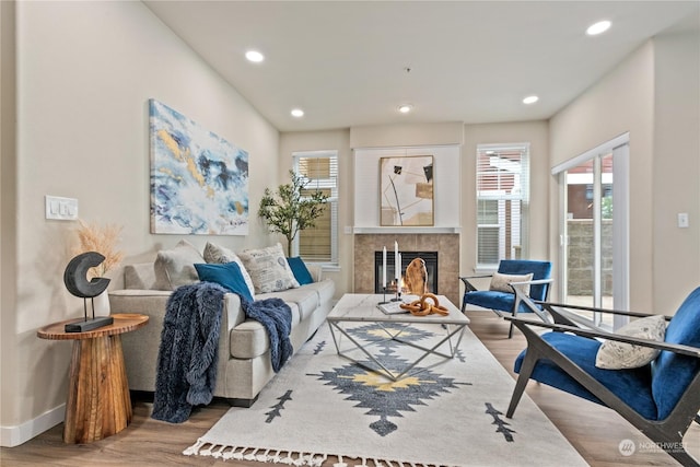 living room with hardwood / wood-style flooring and a tiled fireplace