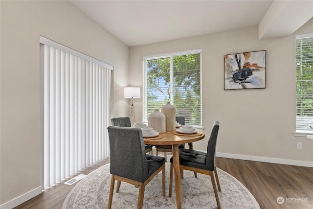 dining room with dark wood-type flooring and a wealth of natural light