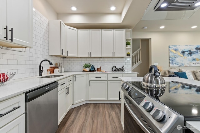 kitchen with sink, dark wood-type flooring, stainless steel appliances, and white cabinets