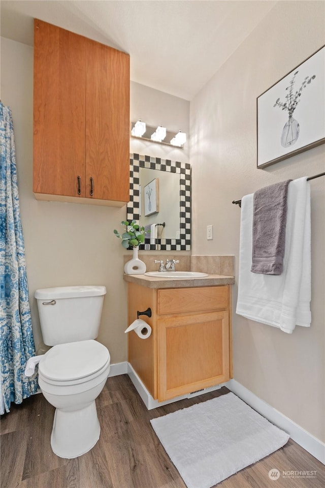 bathroom with vanity, hardwood / wood-style flooring, and toilet