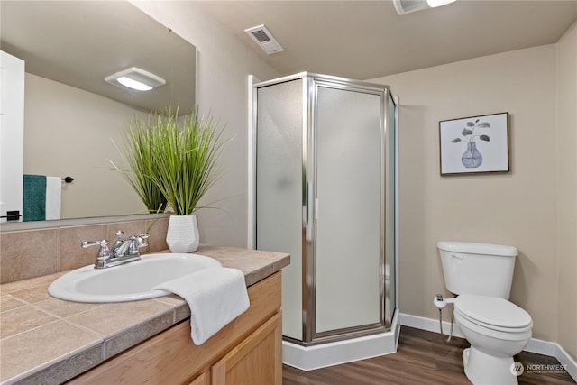 bathroom featuring toilet, a shower with shower door, vanity, hardwood / wood-style flooring, and decorative backsplash