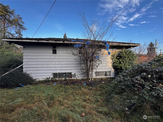 view of side of home with a lawn