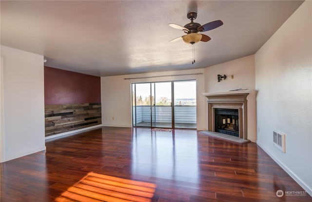 unfurnished living room with ceiling fan and dark hardwood / wood-style flooring