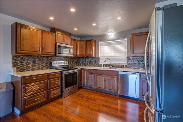 kitchen featuring sink, decorative backsplash, stainless steel appliances, and dark hardwood / wood-style floors