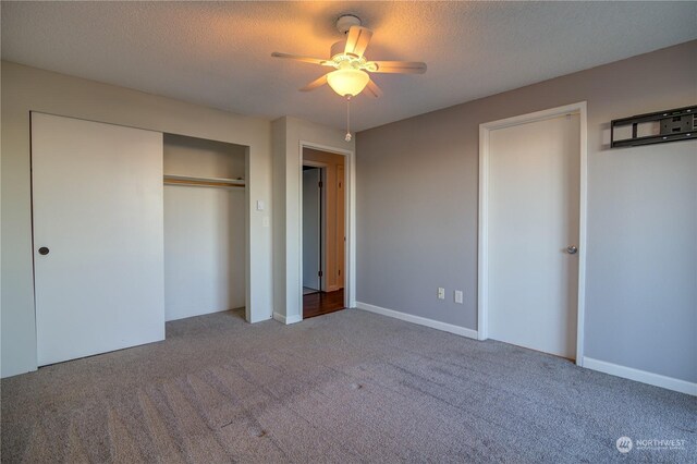 unfurnished bedroom featuring ceiling fan, a closet, a textured ceiling, and carpet