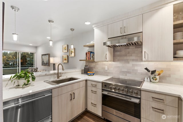 kitchen with stainless steel appliances, sink, light brown cabinets, and decorative light fixtures