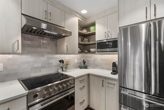 kitchen with light stone counters, stainless steel appliances, and decorative backsplash