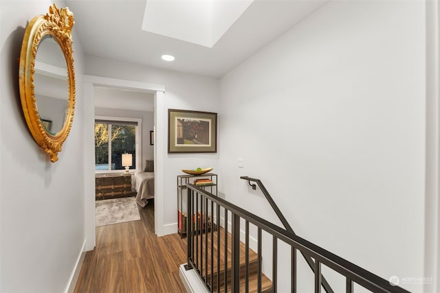 hallway featuring hardwood / wood-style flooring and a skylight