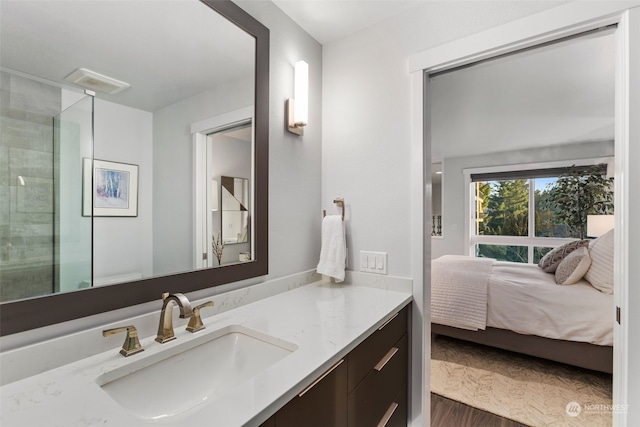 bathroom with vanity, a shower with shower door, and wood-type flooring